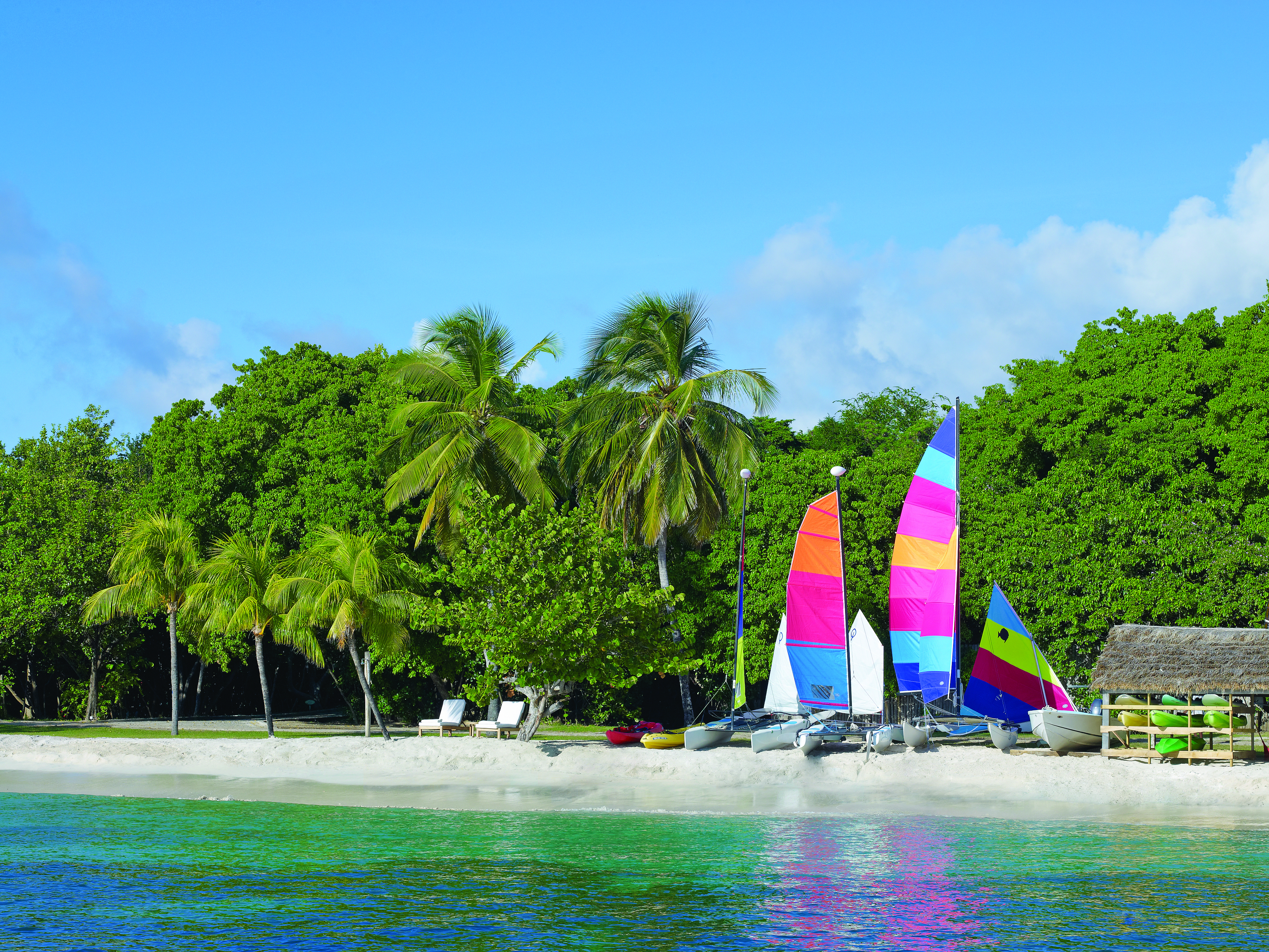 Petit St Vincent boats moored on the beach palm trees