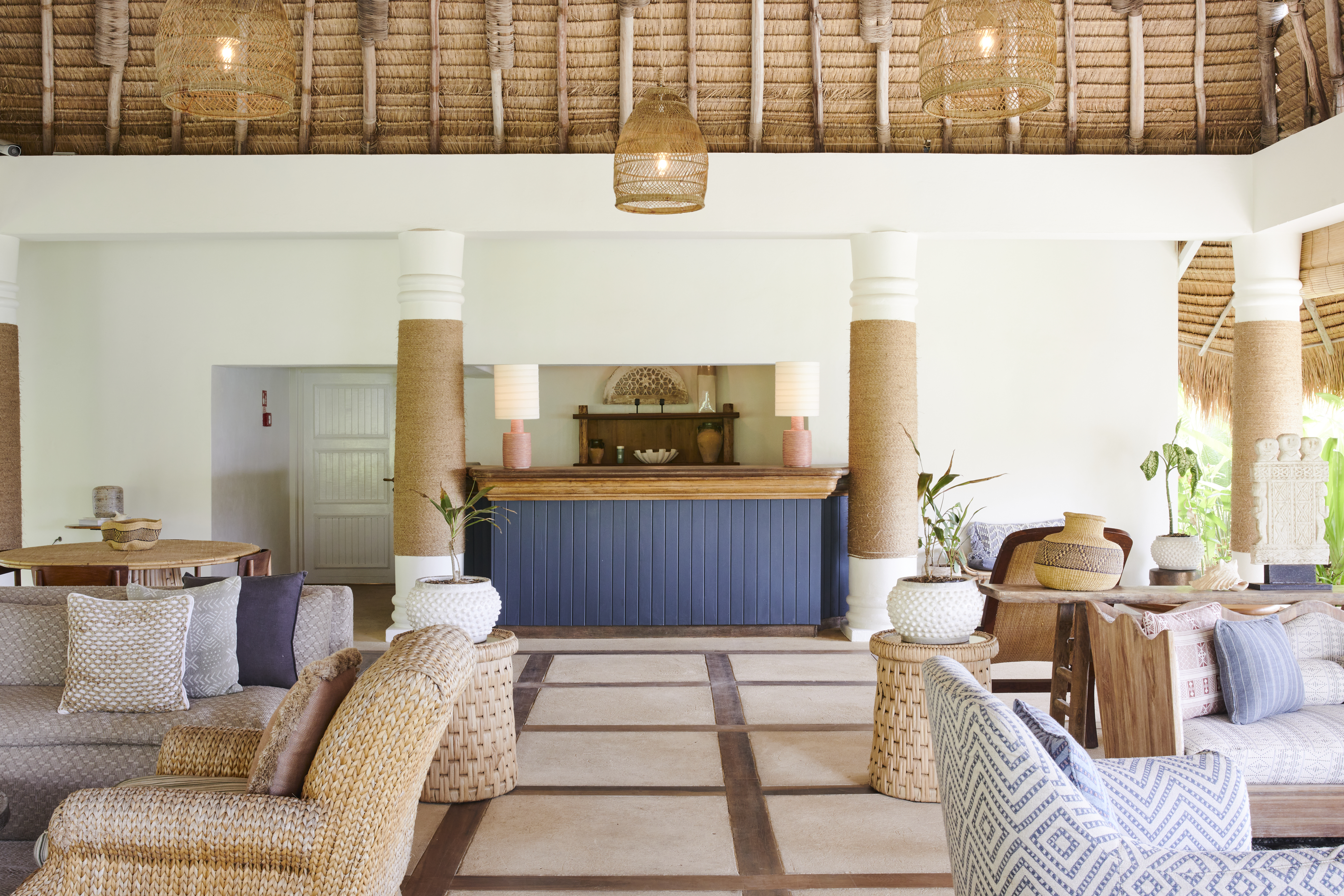 Soho Beach House Canouan Reception with blue desk, vaulted ceiling, and low comfortable light sofas