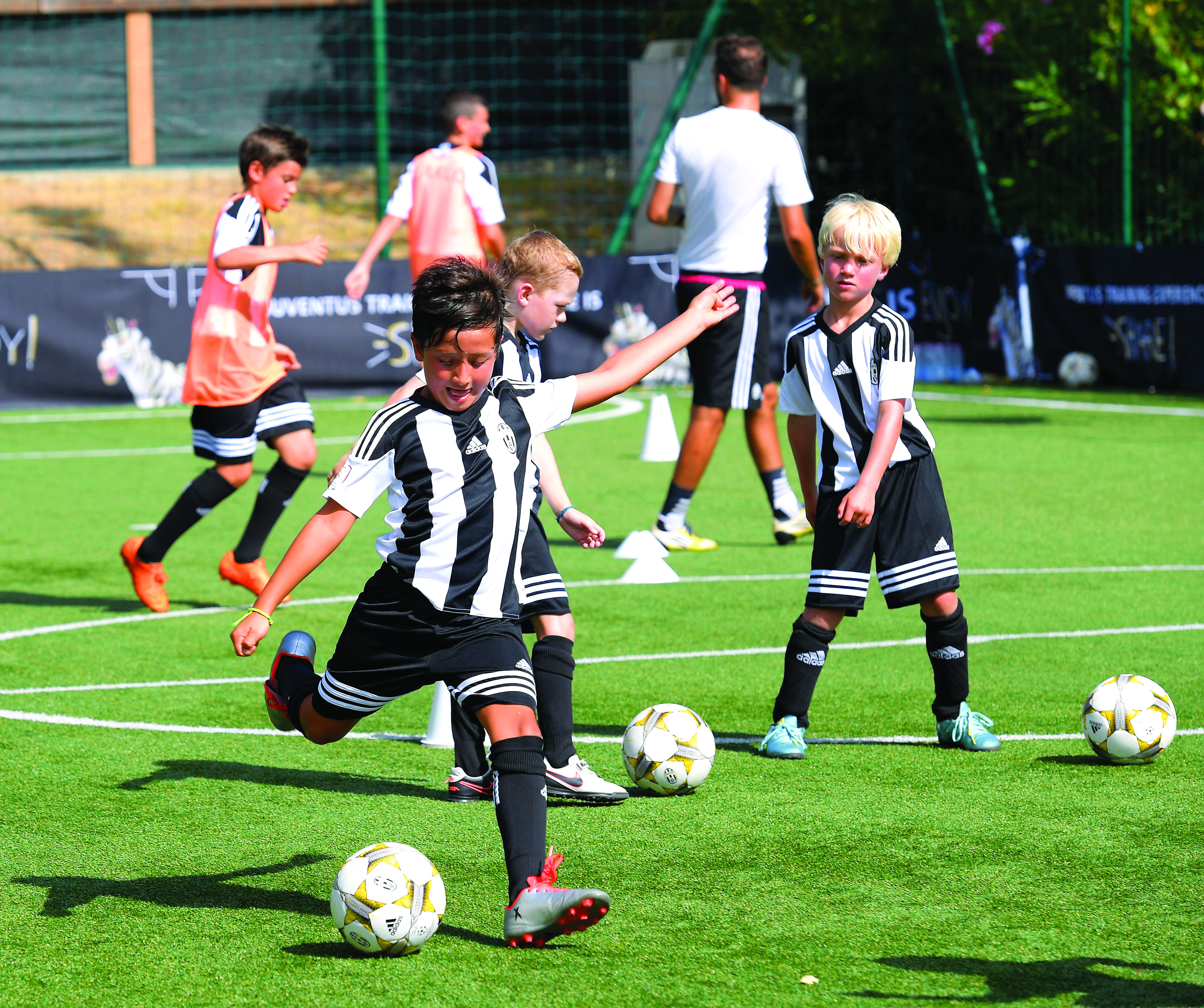 Boys in black and white shirts playing football