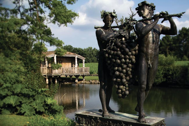 Statue of two people holding bunch of grapes