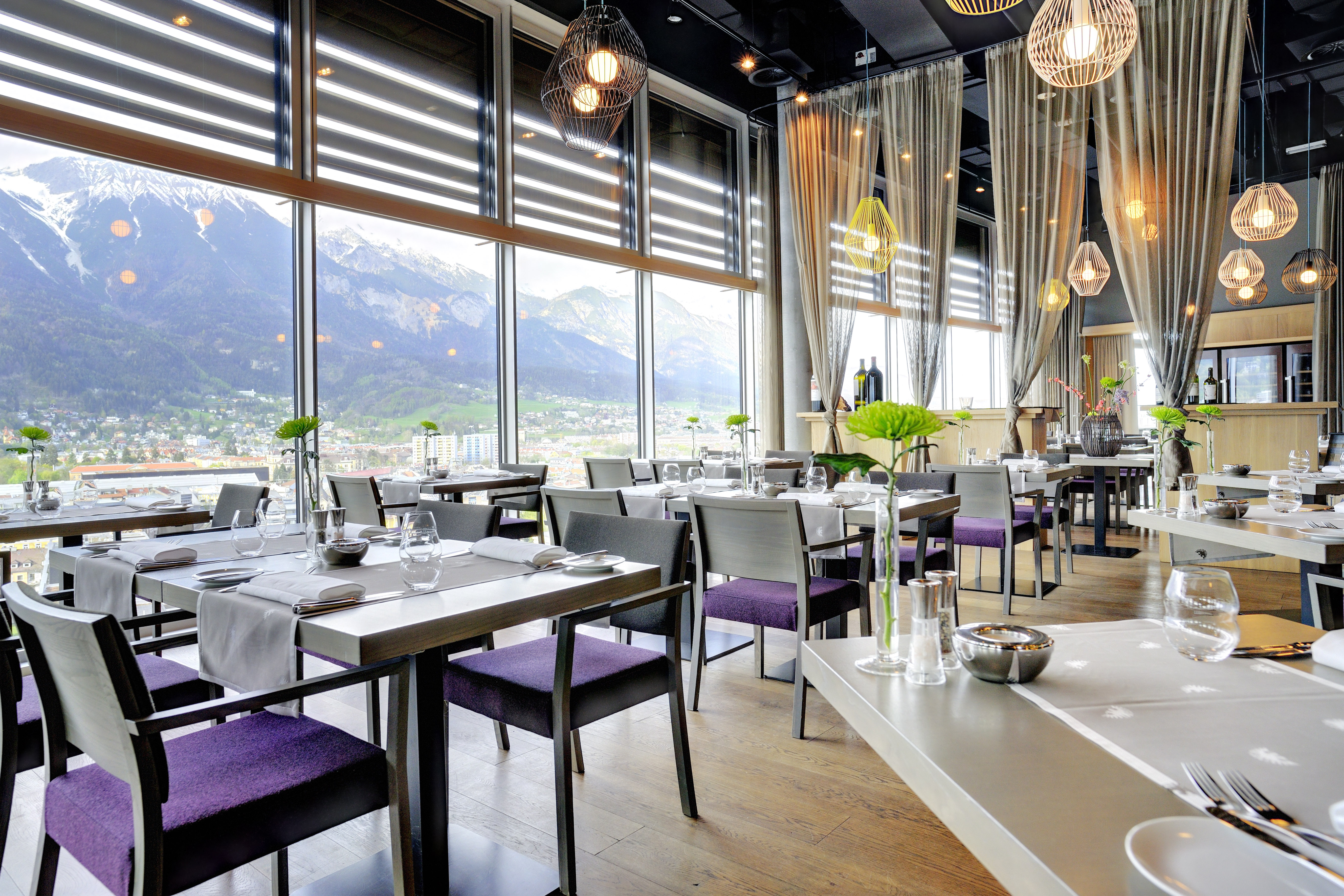 Adlers Hotel Austria Restaurant tables set up for food with large glass windows in the background looking out to mountains in the background