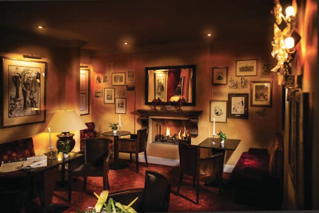 Hotel Bristol Salzburg bar with dim lighting, paintings on the walls and seating areas