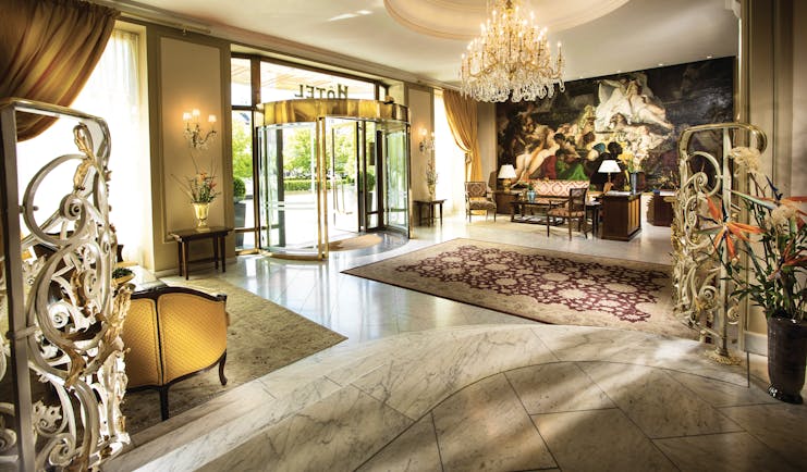 Hotel Bristol Salzburg lobby with grand chandelier, high ceilings, revolving entrance door and rug