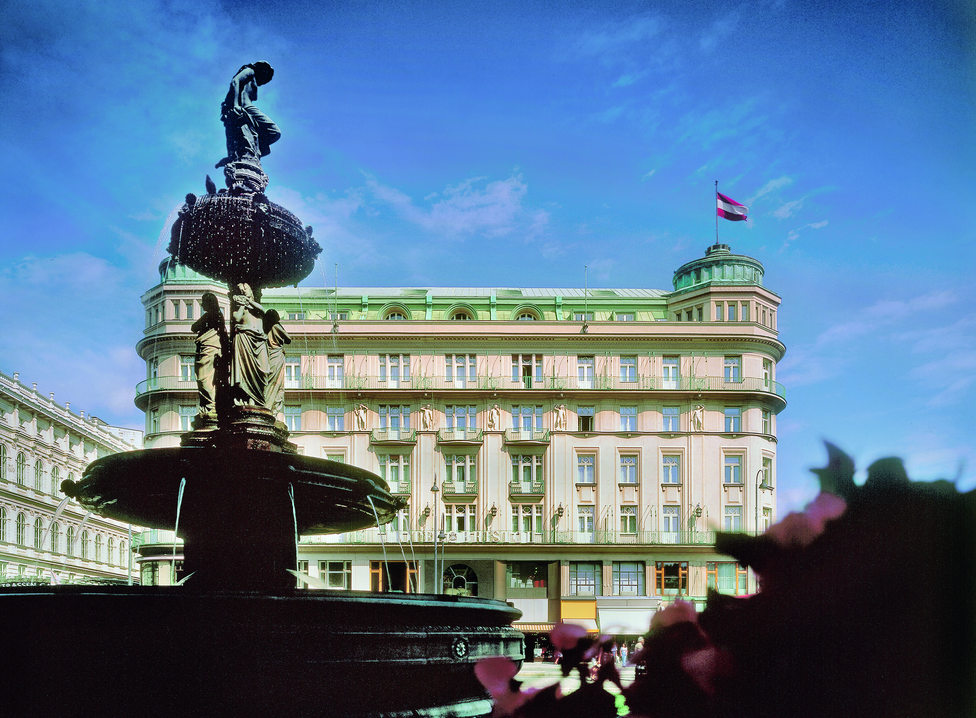 Hotel Bristol Vienna exterior fountain with sculptures of people overlooking large cream building