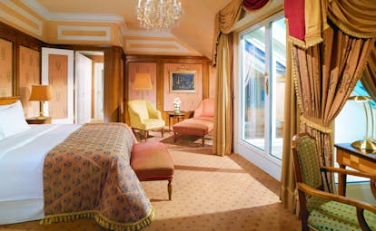 Hotel Bristol Austria Vienna junior suite with a large double bed within a spacious room with chairs in both corners of the room