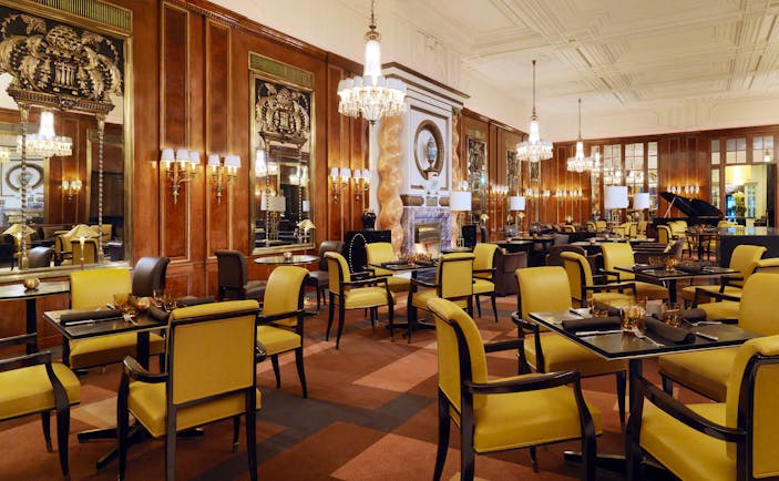 Hotel Bristol lounge, large spacious room occupied by tables for four with chandeliers hanging from the ceiling
