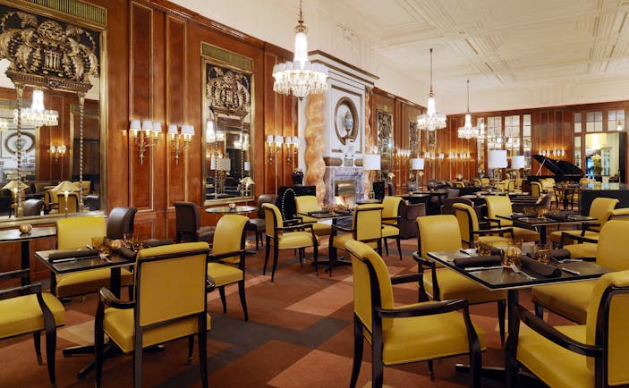 Hotel Bristol lounge, large spacious room occupied by tables for four with chandeliers hanging from the ceiling