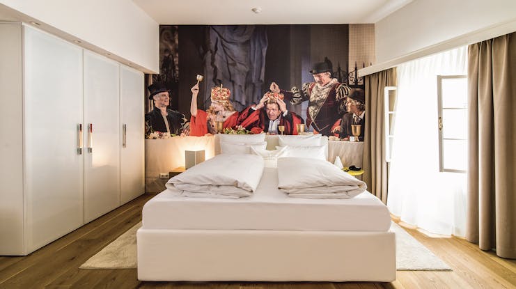 Hotel Goldgasse double bed at the centre of a spacious room on a wooden floor