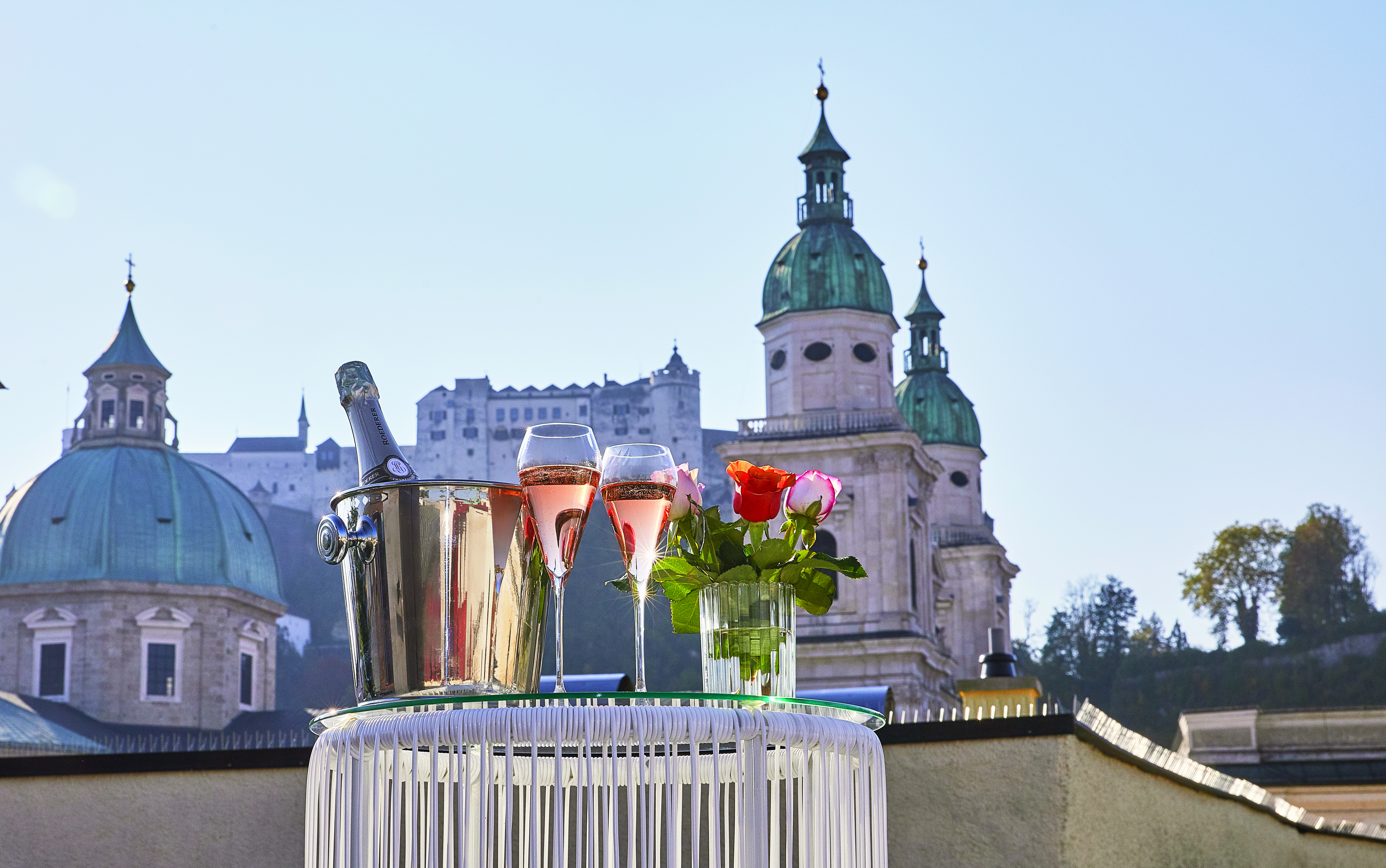 Hotel Goldgasse exterior view with a bottle of wine and two glasses of rose in the foreground