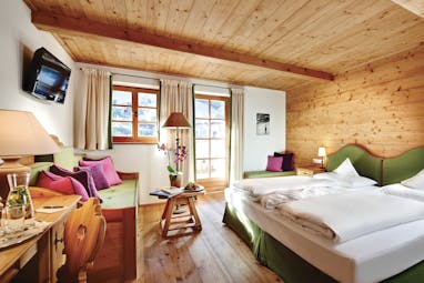 Standard suite with wood pannelled ceiling and floor and wooden window opening onto a balcony 