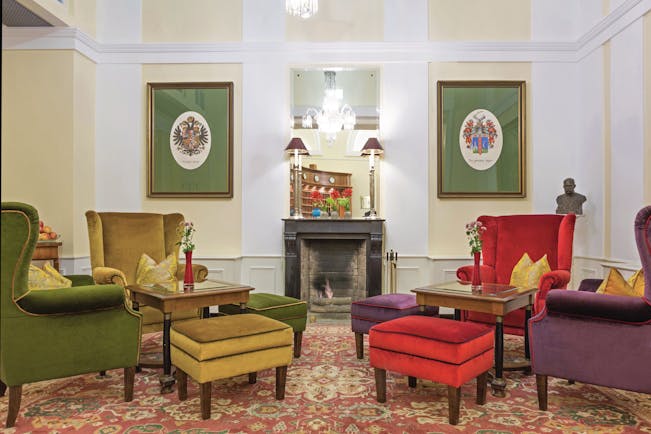 Hotel Kaiserhof Vienna lobby lounge area winged armchairs fireplace and two pictures of coats of arms