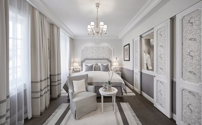 Hotel Sacher deluxe room, double bed, armchair, elegant decor 