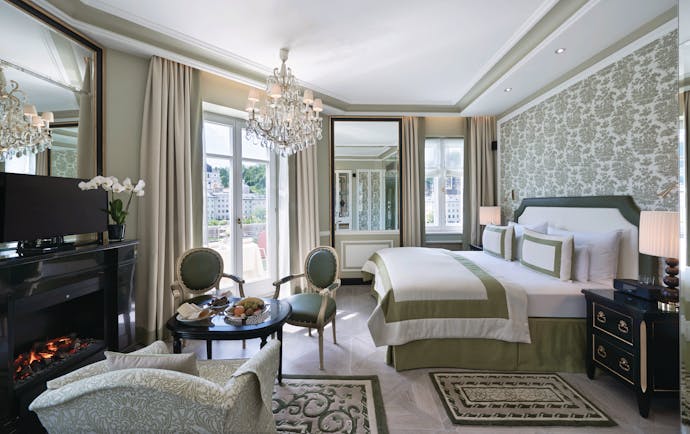 Hotel Sacher junipt suite, double bed, chairs, armchair, elegant decor, glass chandelier
