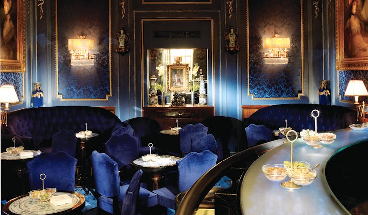 Hotel Sacher Wien Blaue Bar ornate room with a large chandelier at the centre of the room, blue chairs and sofas occupy the room with large paintings on the walls