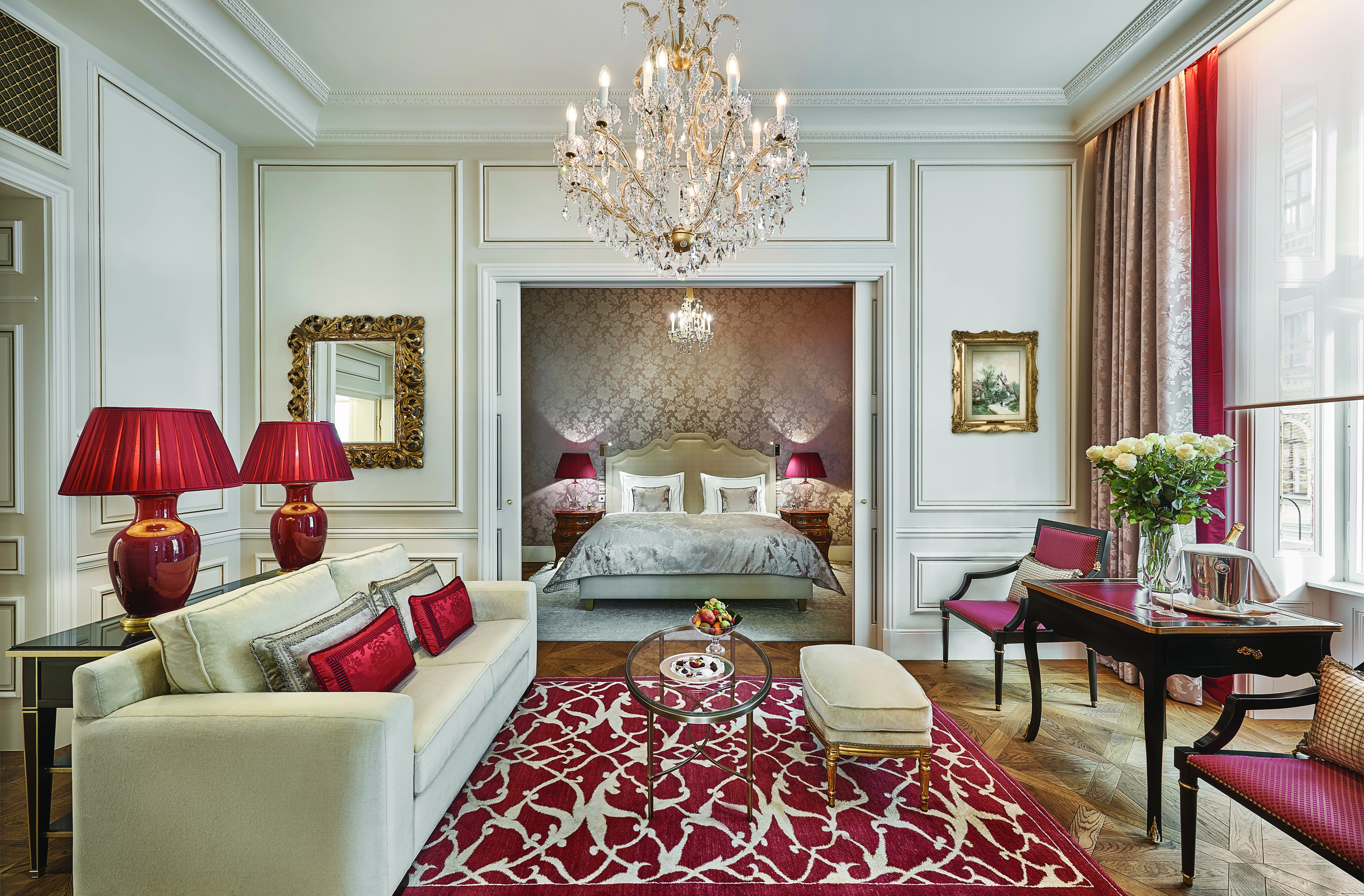 Hotel Sacher Wien Philharmoniker Suite two rooms, one ith a double ed the other with a sofa and tables with a large overhanging chandelier