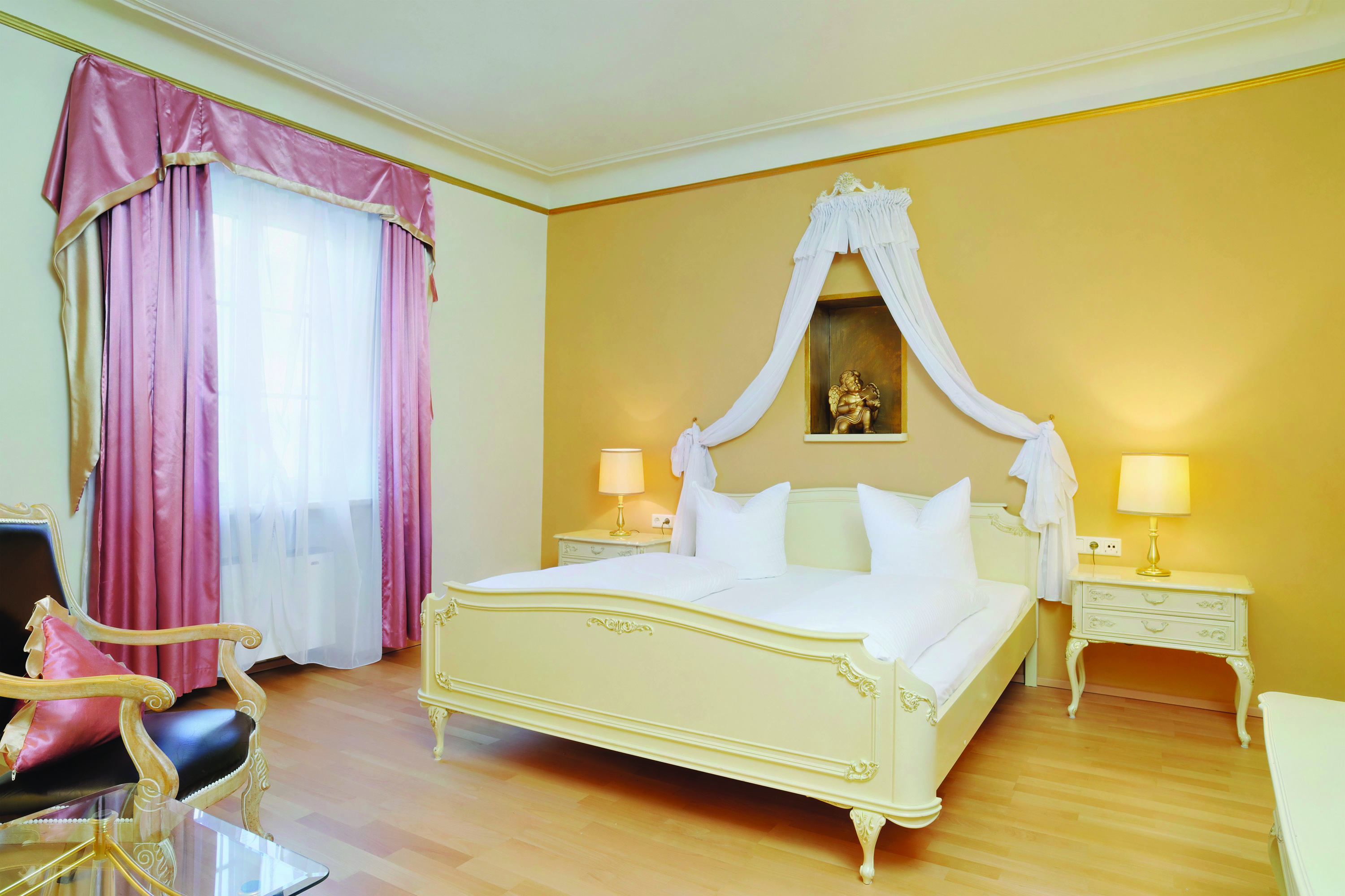Hotel Schwarzer Adler classic room, bright elegant decor, double bed with drapery 