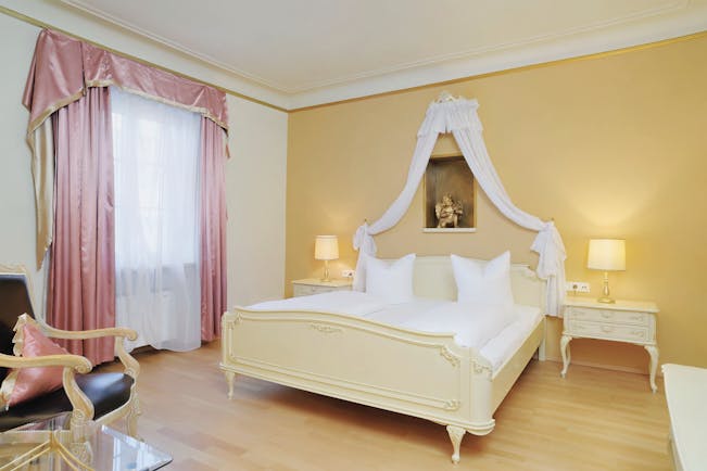 Hotel Schwarzer Adler classic room, bright elegant decor, double bed with drapery 