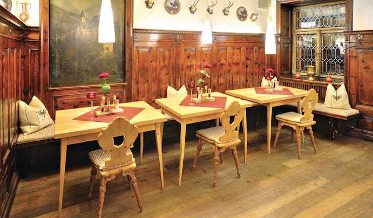 Hotel Schwarzer Adler restaurant, dining tables chairs and benches, traditional decor, wood panelling, paintings