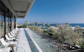Almyra Hotel Cyprus terrace balcony with loungers overlooking trees and sea