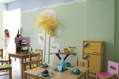 Kids club at the Almyra Hotel with toys around the room, mini tables and chairs set up and flowers painted on the wall