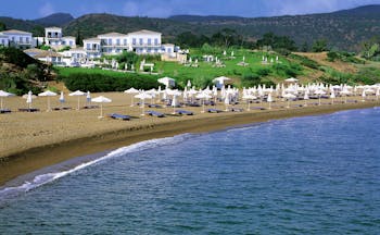 Anassa Hotel beach with white umbrellas and sunbeds 