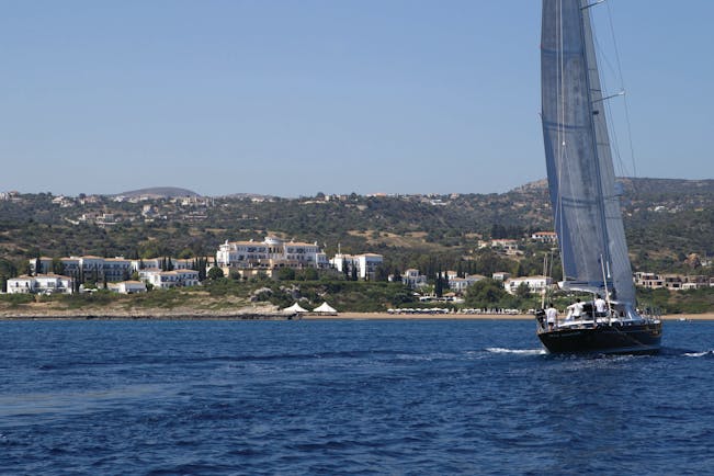 View of the Anassa Hotel from the sea with a sail boat out in front