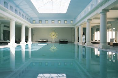 Anassa Hotel indoor pool with white pillars around the dge of the pool and a large glass ceiling