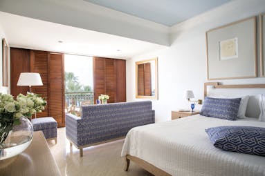 Annabelle Hotel Cyprus deluxe suite sea bedroom blue and white sofa and wooden doors to a balcony