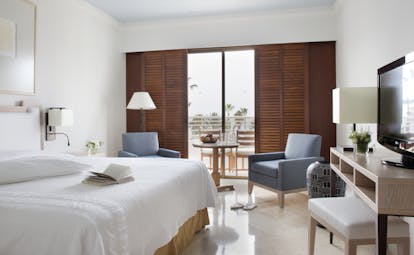 Annabelle Hotel Cyprus studio suite bedroom desk and wooden doors to a balcony