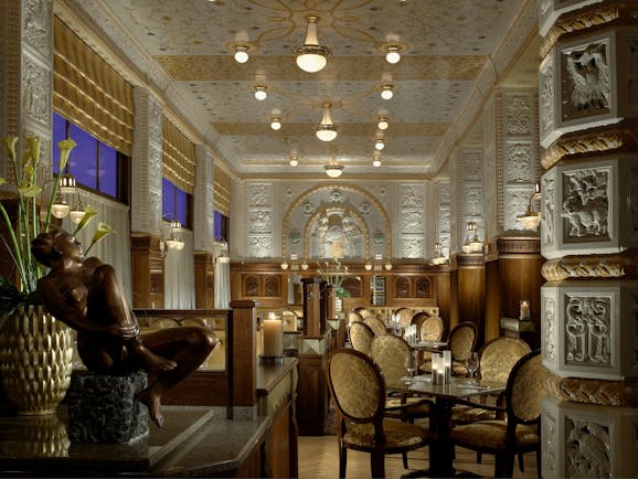 Art Deco Imperial resturant, grand lavish decor, statues, carved walls and columns, tables and chairs