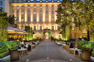 Grand Mark Prague exterior, hotel building, walkway to entrance with lawned gardens on each side, outdoor seating area