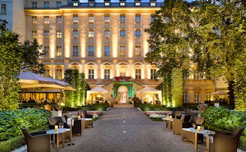 Grand Mark Prague exterior, hotel building, walkway to entrance with lawned gardens on each side, outdoor seating area