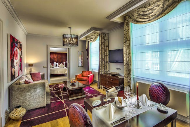 Grand Mark Prague family suite living area, tables and chairs, sofa, bedroom through door, colourful modern decor