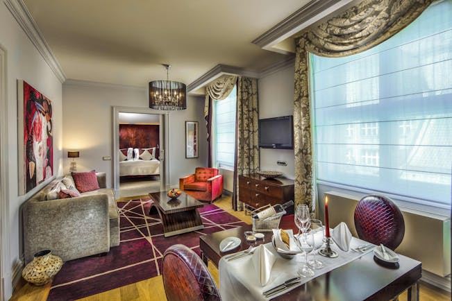 Grand Mark Prague family suite living area, tables and chairs, sofa, bedroom through door, colourful modern decor