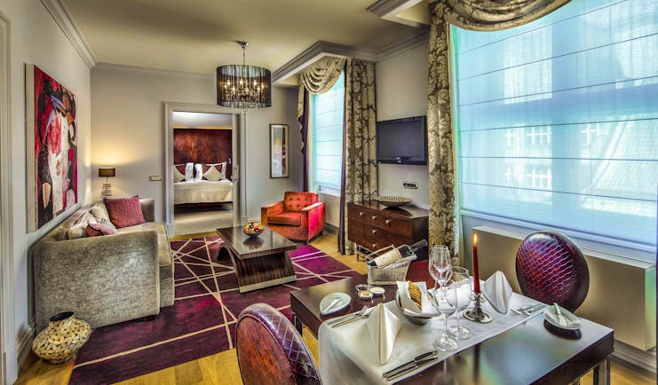 Grand Mark Prague family suite living area, tables and chairs, sofa, bedroom through door, colourful modern decor