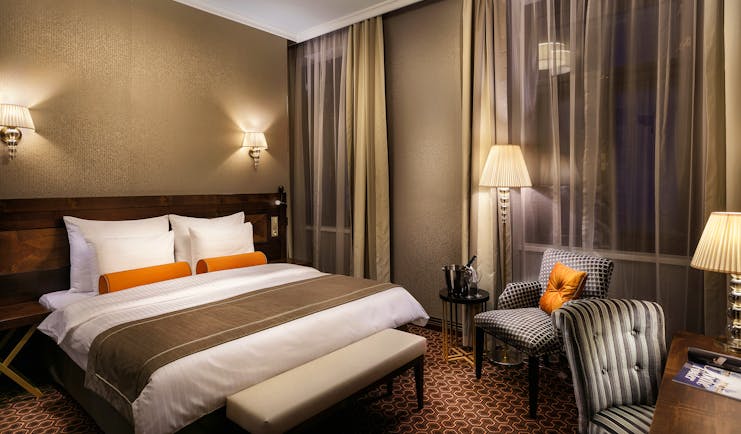 Executive king room with double bed, lamp shades and arm chairs