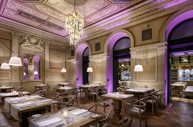 Restaurant with tables and chairs set up and chandelier