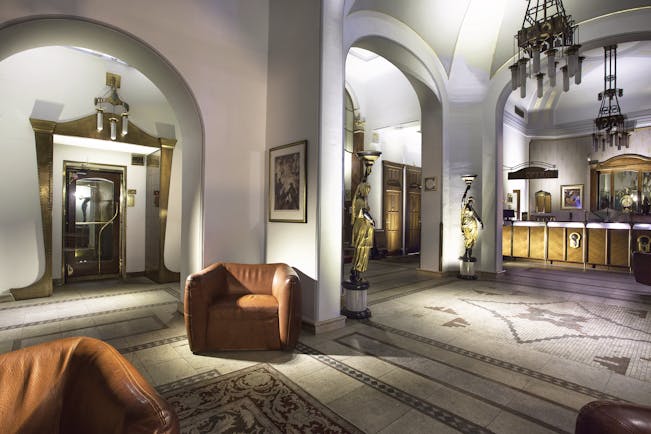 Hotel Paris Prague lobby area  archways mosaic floors chairs and two statue lamps