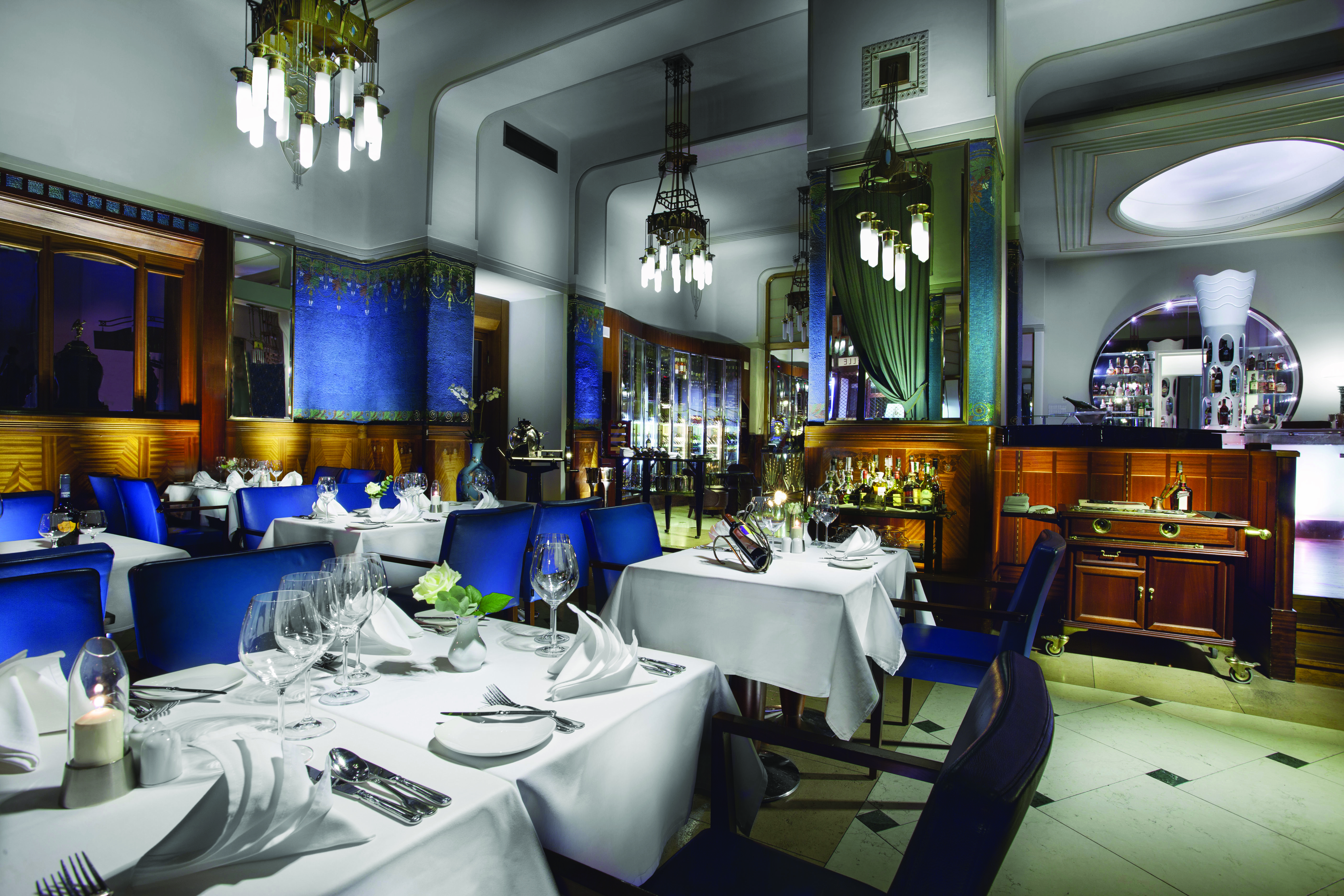 Hotel Paris Prague restaurant Sarah Bernhardt  indoor dining area with wooden panelled walls and chandeliers
