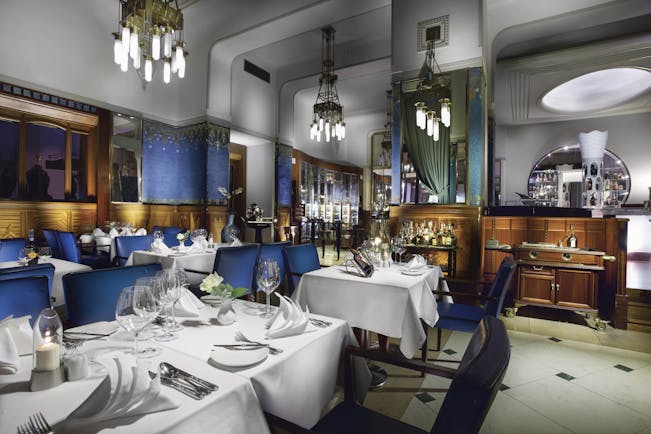 Hotel Paris Prague restaurant Sarah Bernhardt  indoor dining area with wooden panelled walls and chandeliers