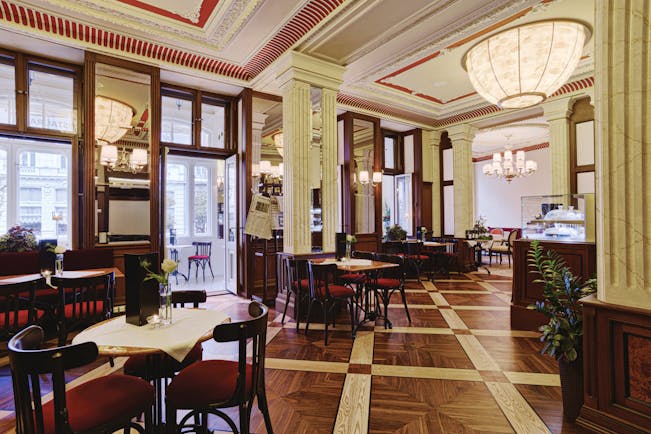Hotel Quisisana Palace Karlovy Vary restaurant dining room wood panelling wooden floors large windows and ornate ceiling