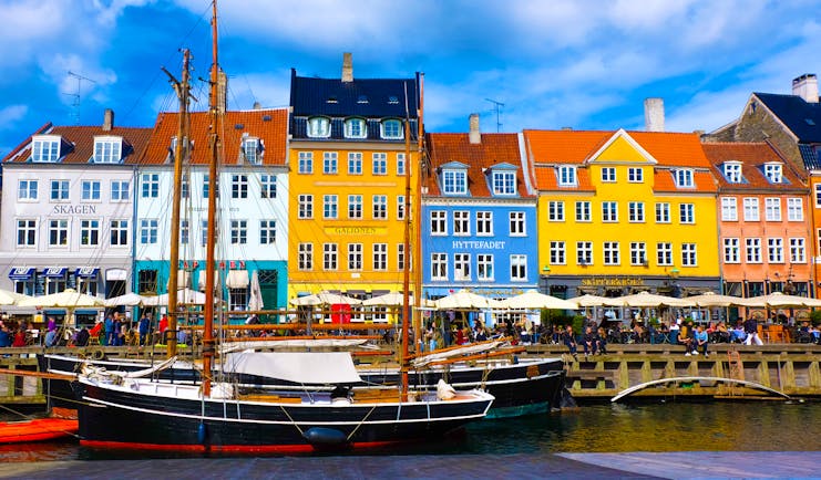 Coloured old houses on quayside by water and sailing boat