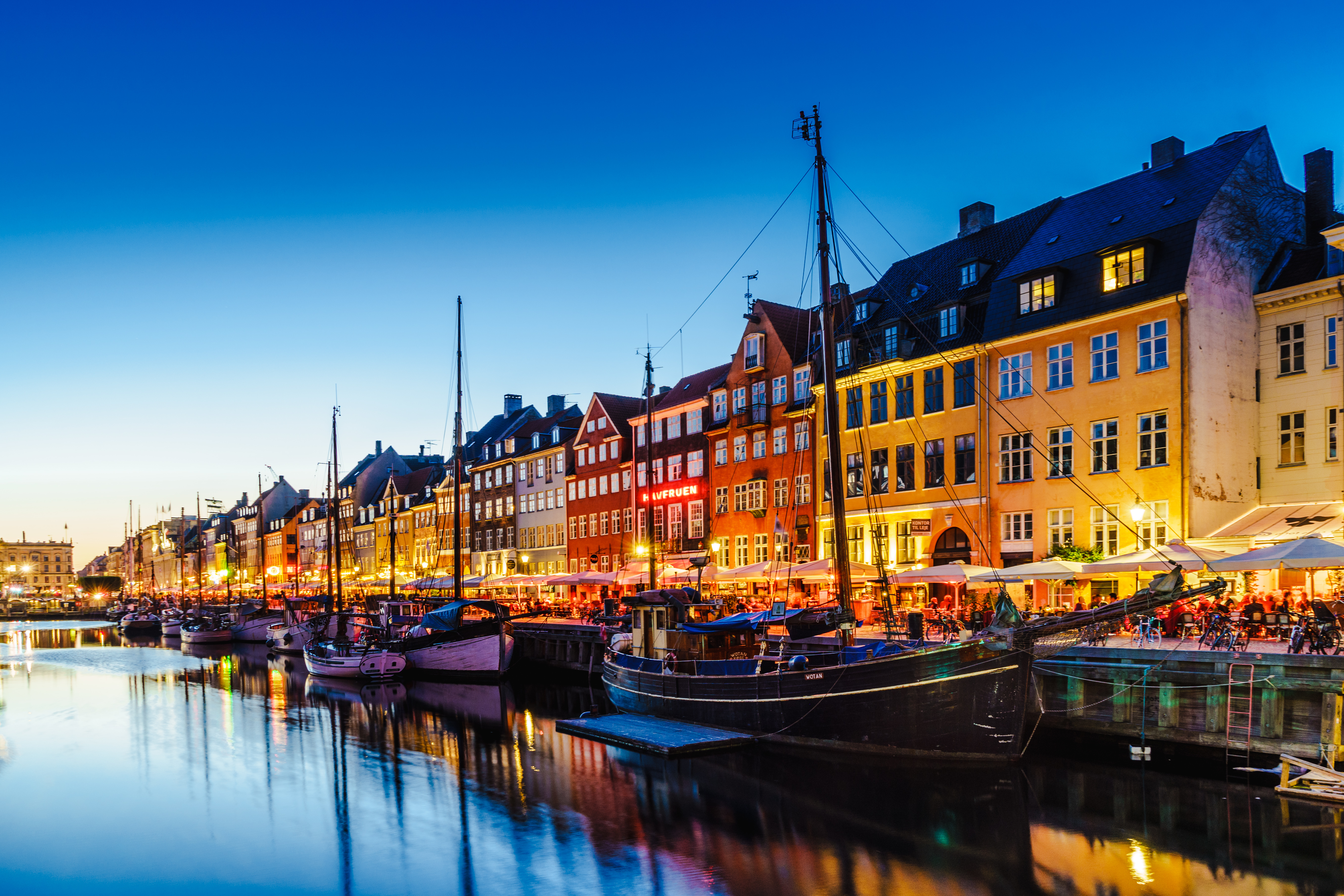 Evening picture with illuminated houses by edge of water