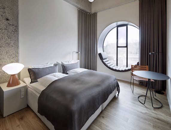 Hotel Ottilia superior room, double bed, round window with window seat, scandinavian decor