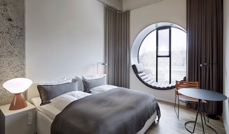 Hotel Ottilia superior room, double bed, round window with window seat, scandinavian decor