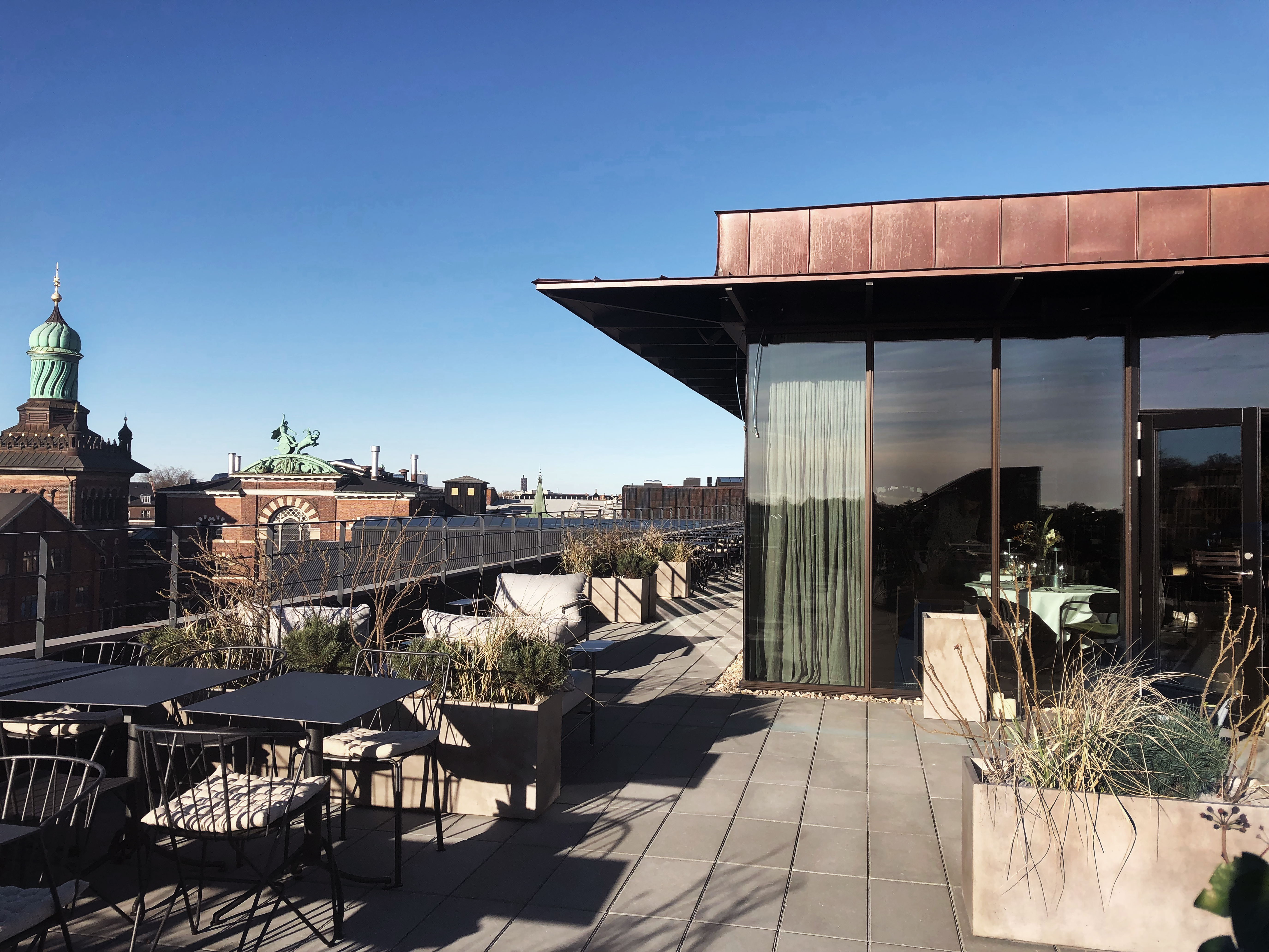 Hotel Ottilia terrace, outside seating area, tables and chairs, blue sky