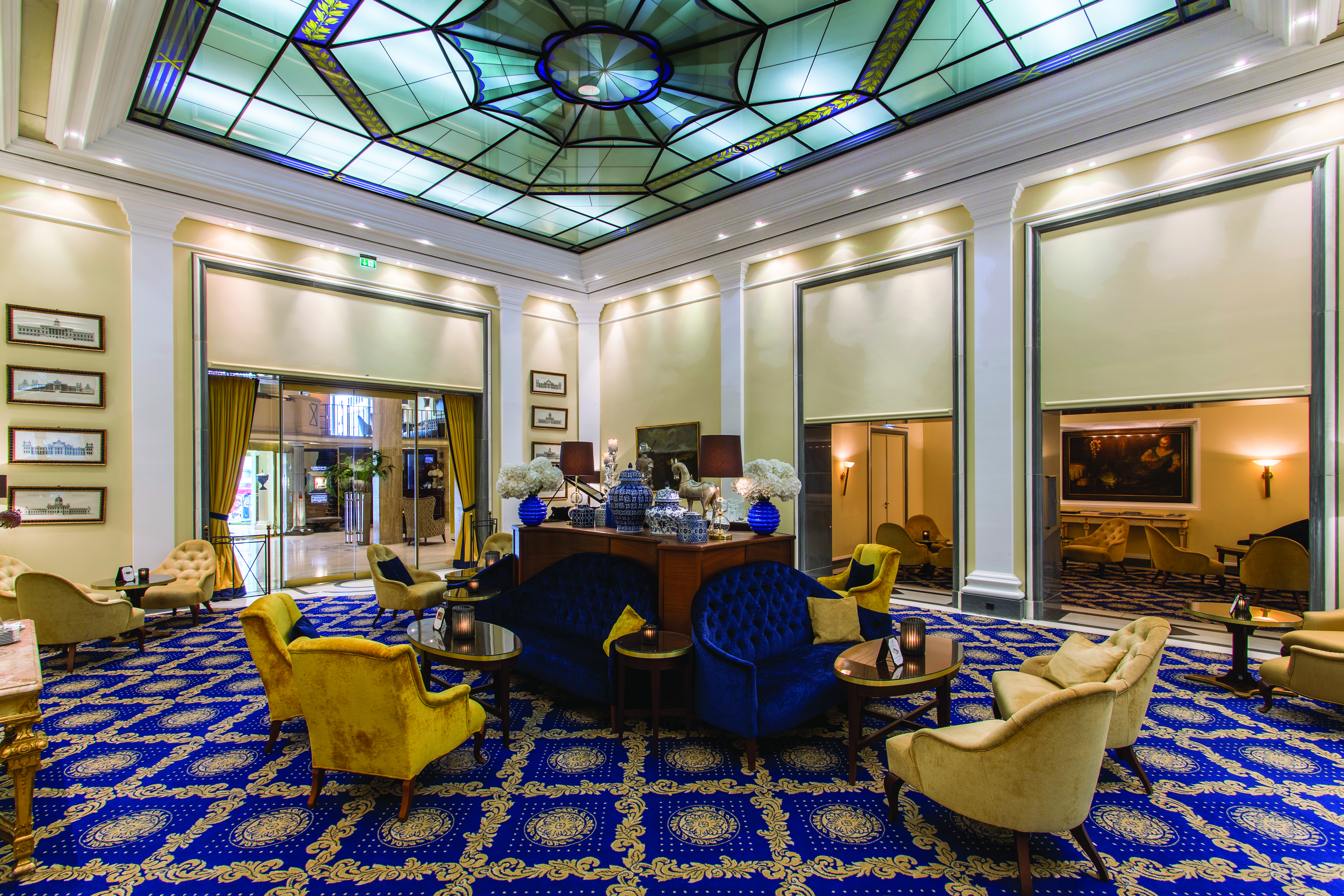 Excelsior Hotel Ernest Cologne winter garden stained glass ceiling blue sofas and cream chairs and tables