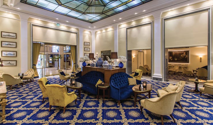 Excelsior Hotel Ernest Cologne winter garden stained glass ceiling blue sofas and cream chairs and tables