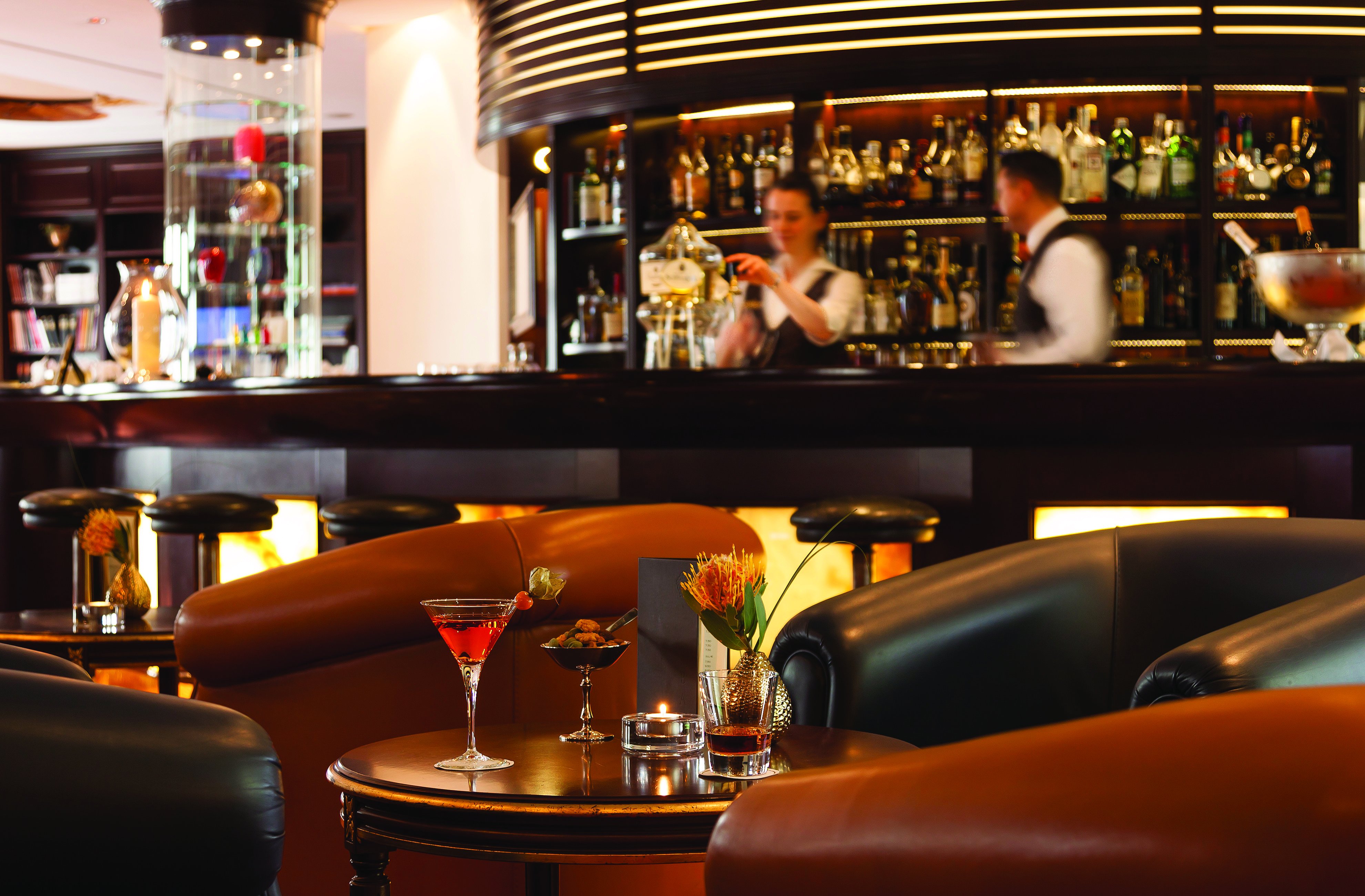 Bar and sitting area at the Hotel Bulow Palais with wooden pannels, a wooden bar and leather arm chairs 