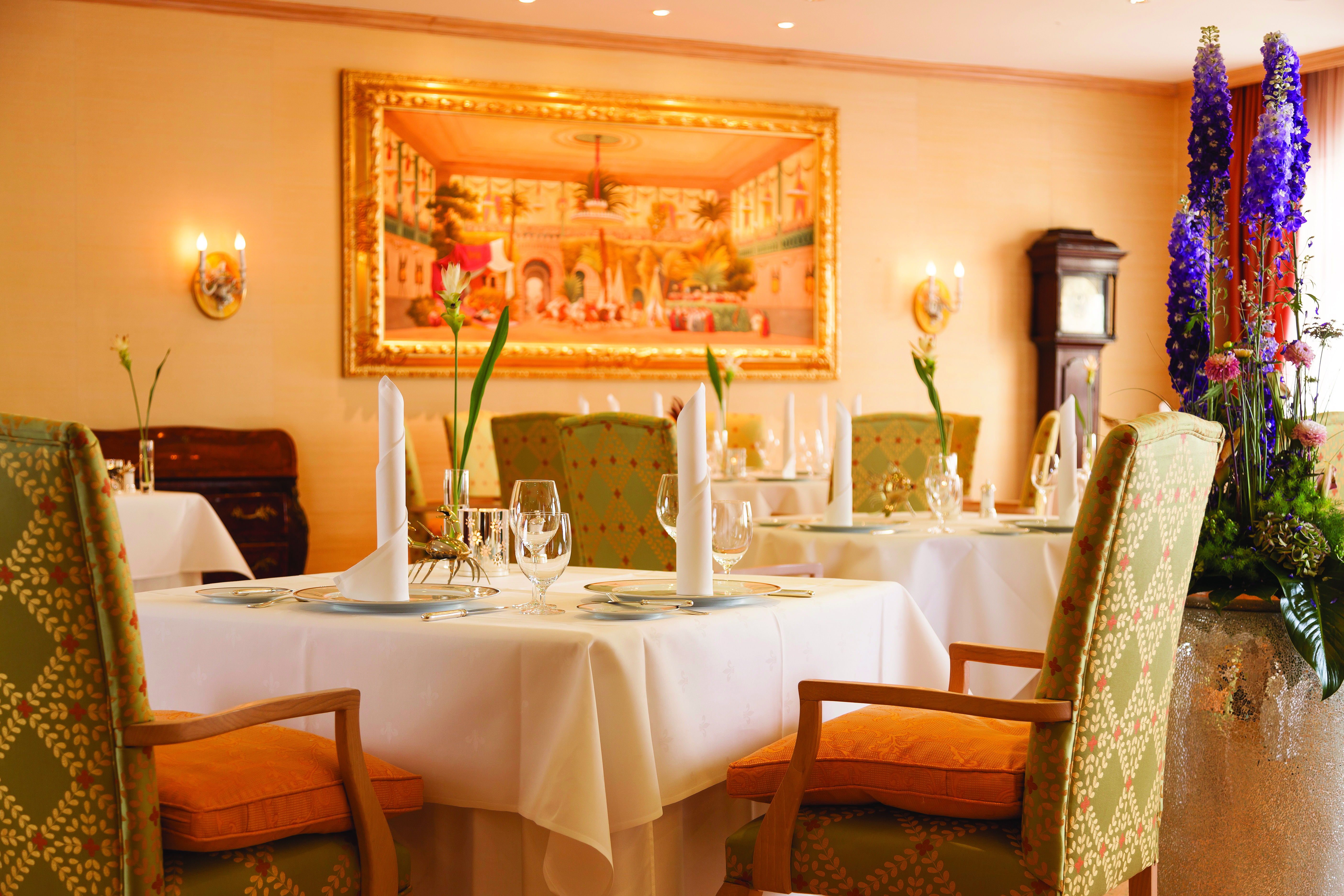 Restaurant dining area at the Hotel Bulow Palais with tables set up around the room and paintings on the walls